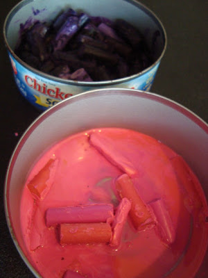 Pink and purple crayons melted in tuna cans