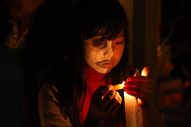 Young girl lighting candles at gravesite