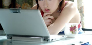Chinese female reading off computer.