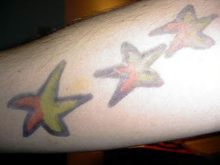 Conjunto de 3 estrelas bicolor tatuadas no antebraço