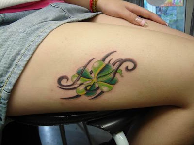 A green flower tattoo with tribal symbol as background.