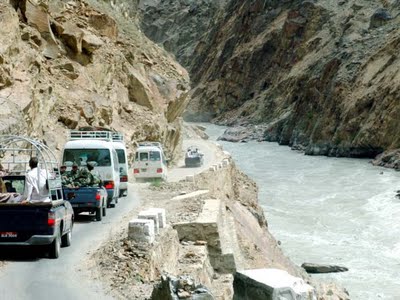 Vehículos pasando al lado de un caudoloso río en la Karakoram Highway