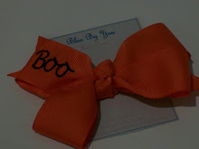 4" bow made with 1 1/2" orange ribbon, embroidered with "Boo"