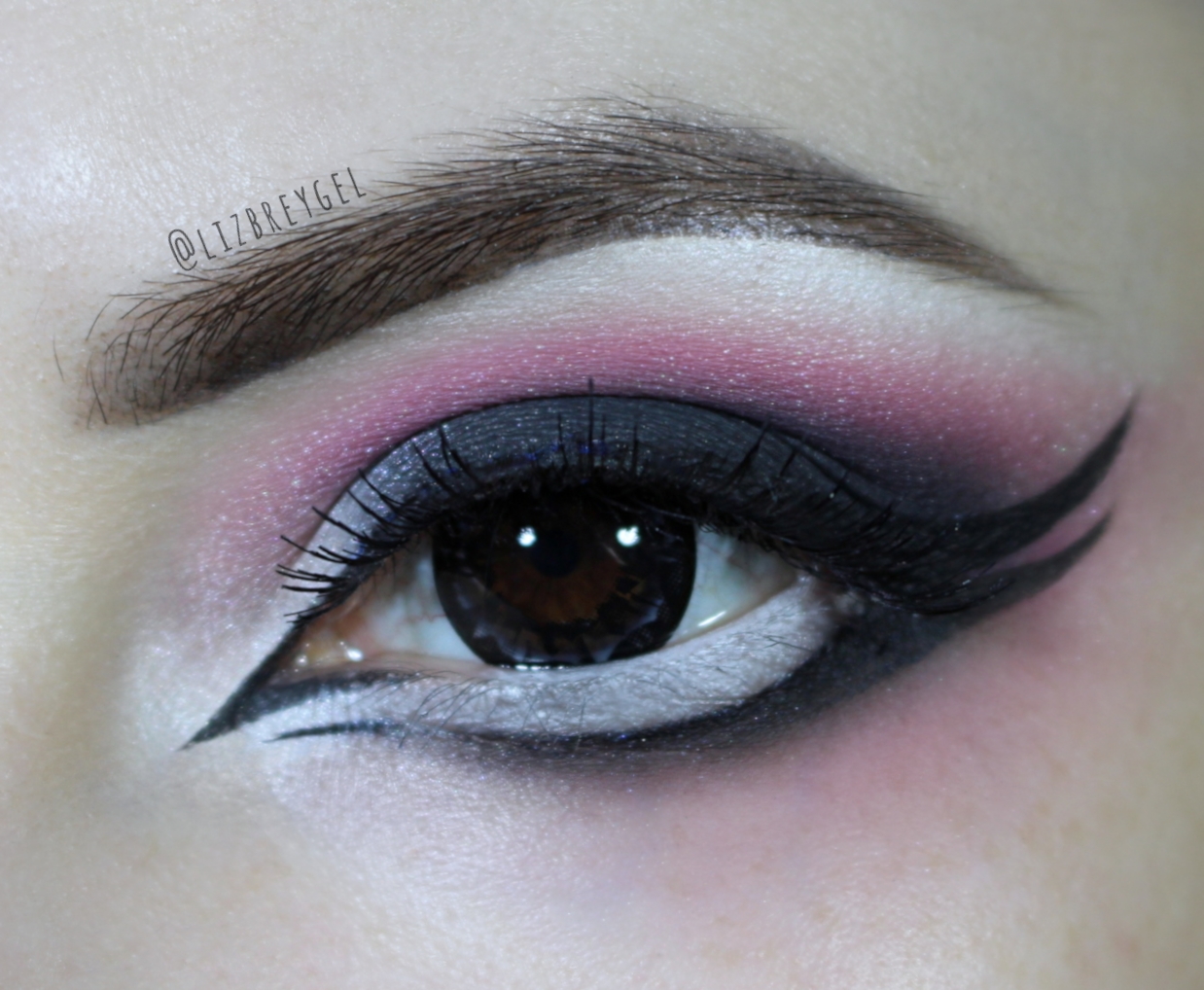 a close-up of a brown eye with dramatic black and pink makeup look inspired by Gothic Lolita subculture