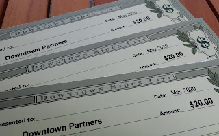 three pale green rectangles of cardstocks are marked as Sioux City Downtown Dollars