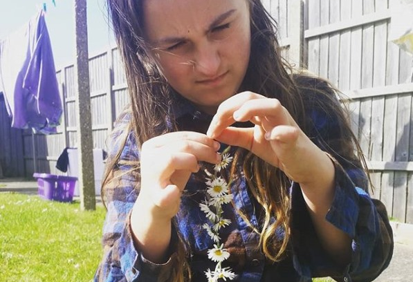 my youngest sat in the garden on the grass making a daisy chain