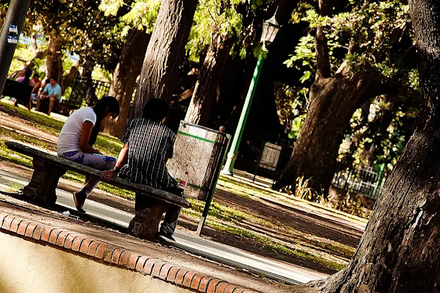 Foto Pareja sentada en silencio en banco de plaza