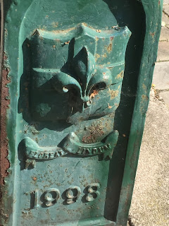 the metal base of a street lamp in Lincoln, painted green