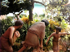 Diorama of two 19th-century Maori being guided along a track in the bush by a third.