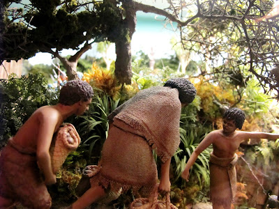 Diorama of two 19th-century Maori being guided along a track in the bush by a third.