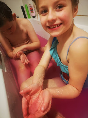 Girl with swim suit on in bathtub with Gelli baff