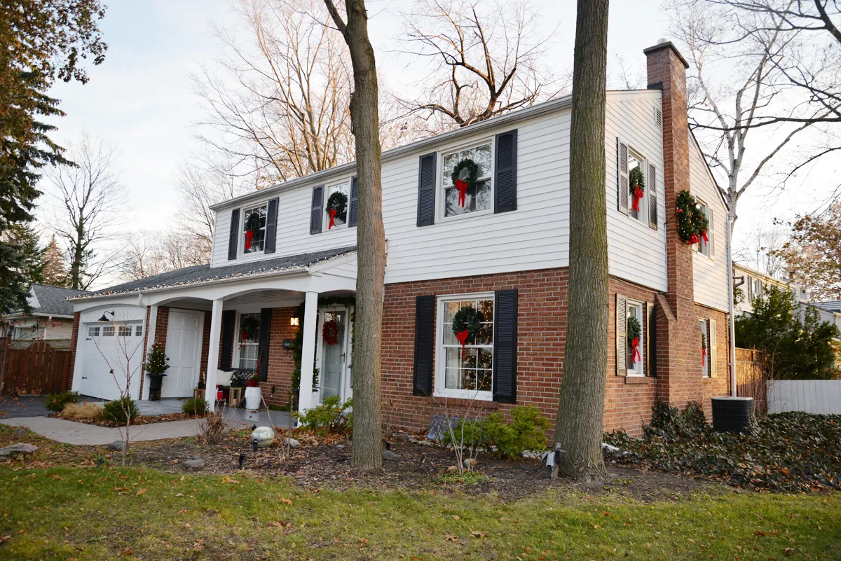 classic christmas decorations, colonial house with wreaths on windows, wreaths on exterior windows