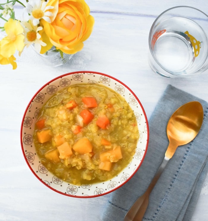 red lentil soup in a white bowl trimmed with blue