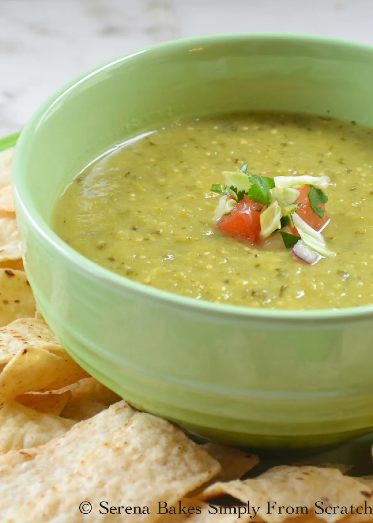 Tomatillo Salsa Verde Recipe in a green bowl with chips on the side.