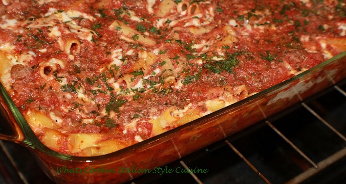 this is baked ziti in a casserole dish in the oven baking