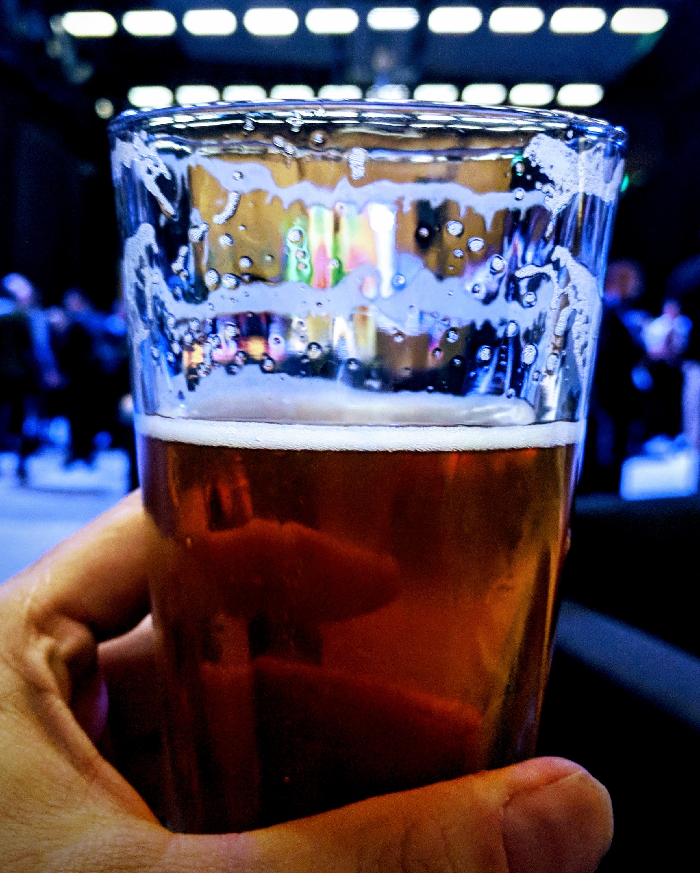 Glass of golden beer in a blue environment