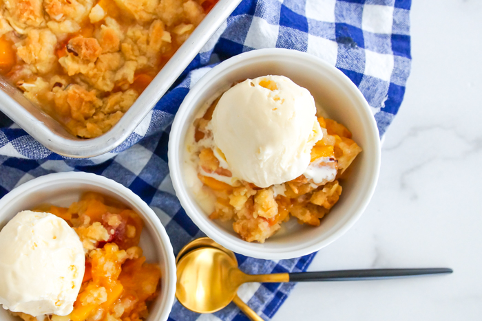 Almond Peach Dump Cake from scratch, topped with vanilla ice cream