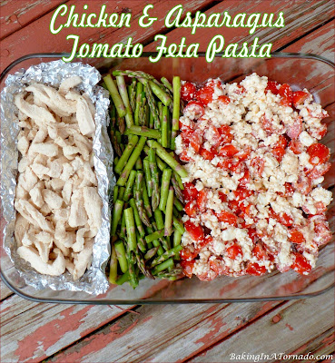 Chicken and Asparagus Tomato Feta Pasta, a version of tomato feta pasta with all of the flavors of the original, and the addition of vegetables, protein, and a little kick. | Recipe developed by www.BakingInATornado.com | #recipe #dinner