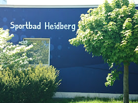 Blaue Wand des Hallenbads mit Aufschrift "Sportbad Heidberg."