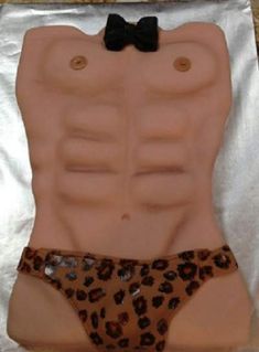 A male torso cake with ring around it
