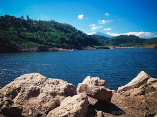 Natural Beauty Lake Water Dam Surrounded By Hills With Chunks Of Rock On A Sunny Day Titab Ularan North Bali Indonesia