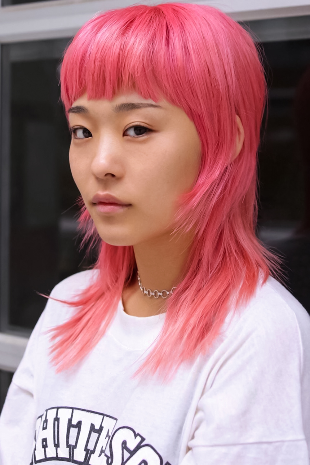 woman with dyed edgy mullet haircut is posing