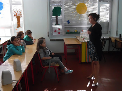 A autora mostra o seu livro aos alunos da EB1 n.º 4, que estão sentados na sua frente.