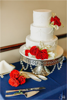 white wedding cake with red flowers