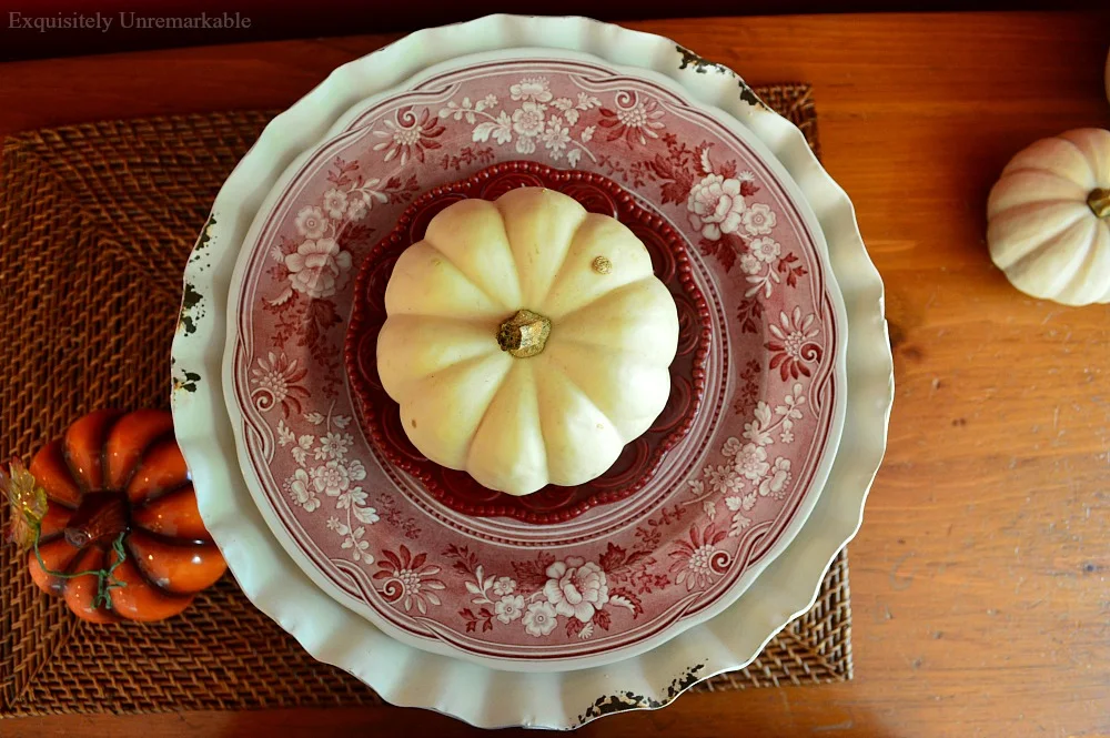 White baby boo pumpkin on red and white plates for fall
