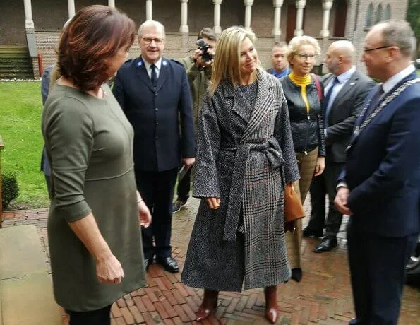 Queen Maxima wore a new mixed-check belted coat by Oscar de la Renta, and carries Uterque bag. Creolen gold earrings, Cartier smartwatch