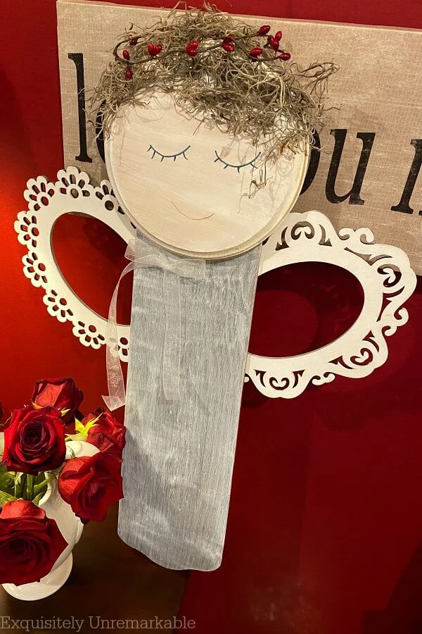 Junk fan blade angel sitting on a table with roses