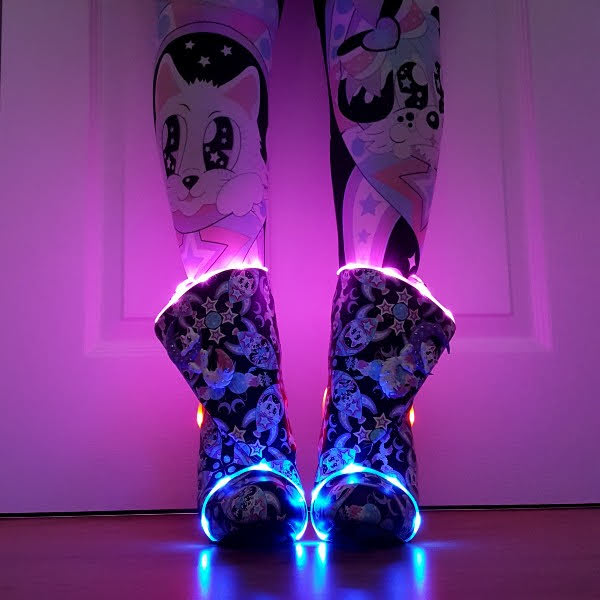 front facing ankle boots being worn in dark room with bright LED lighting in them