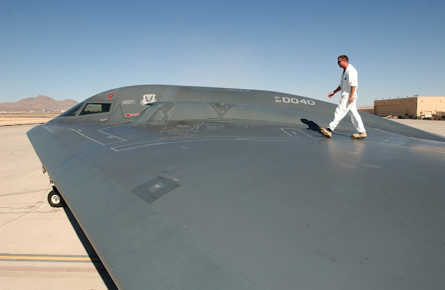 Tech. Sgt. Kevin Ponton examines the wing surface of a B-2 Spirit Bomber