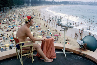 A lifeguard watching over swimmers from a lookout, circa 1966, from National Archives of Australia
