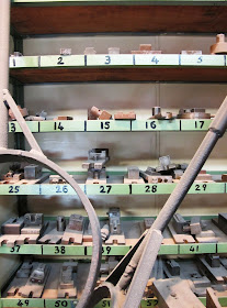 Pieces of metal arranged on numbered shelves.