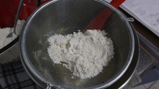 sifting the almond meal - icing sugar into the whipped egg whites
