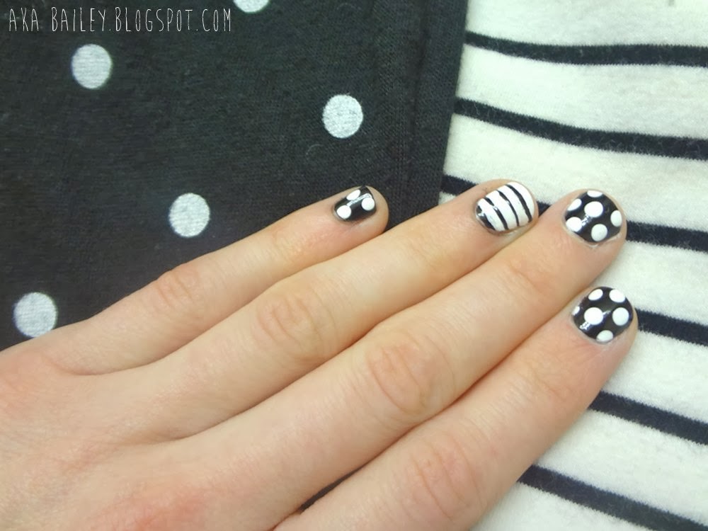 Black nails with white polka dots, white nail with black stripes as an accent nail