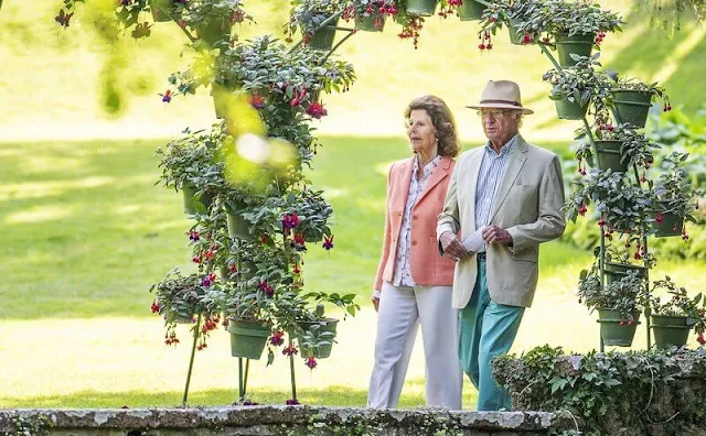 Queen Silvia wore pink blazer and white trousers. Silvia wore a floral print silk blouse
