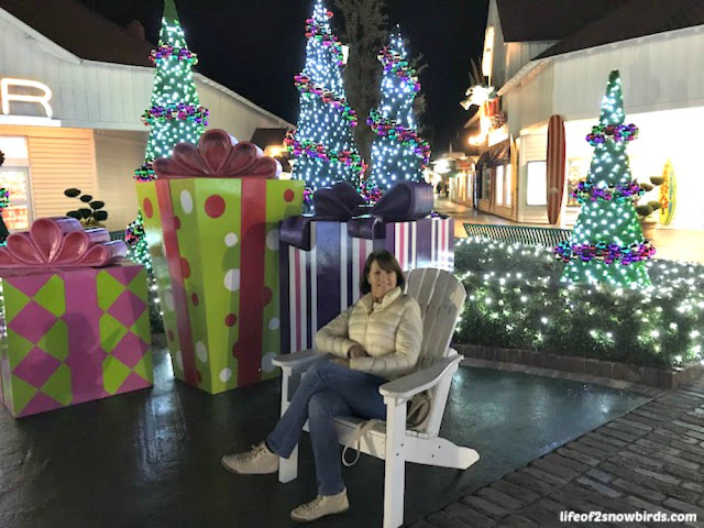 Woman sitting on a chair surrounded by holiday lights at Broadway at the Beach in Myrtle Beach.