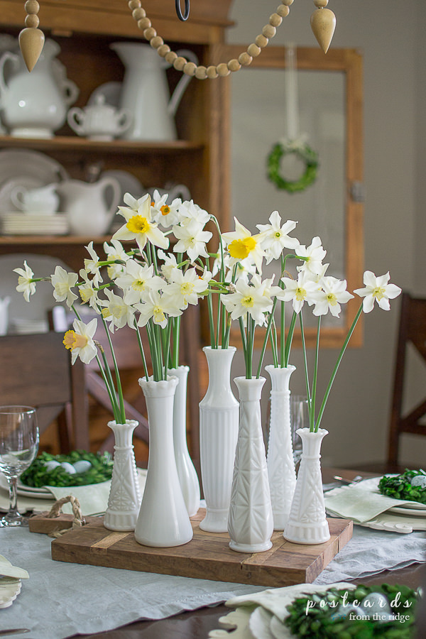 white milk glass vases with daffodils used as a centerpiece