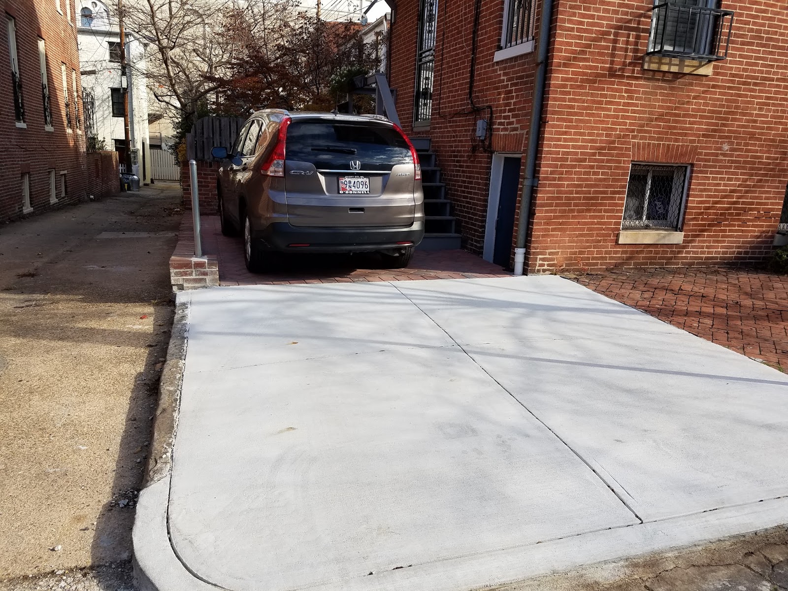 Custom Stoneworks & Design Inc. Paver parking pad with concrete