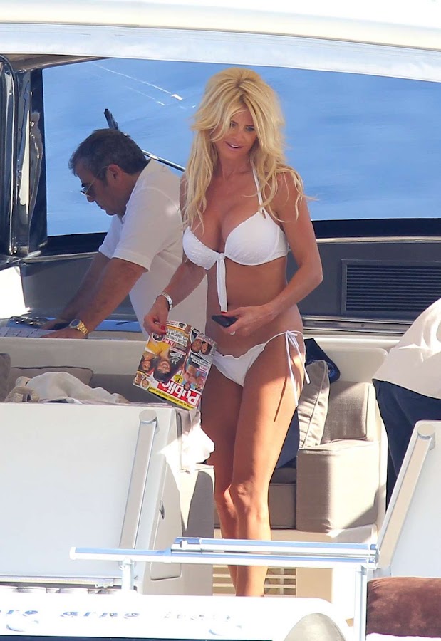 Victoria Silvstedt in a white bikini and a magazine in her hand