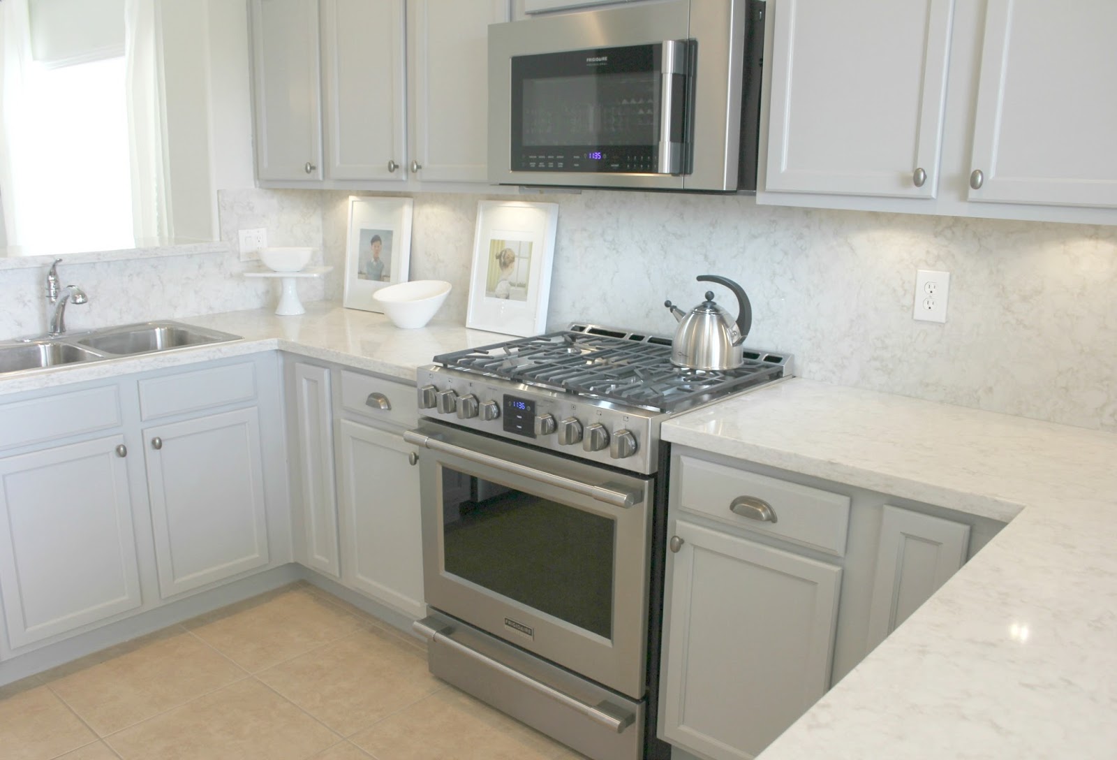 Serene chic simple Nordic French kitchen with grey cabinets and Soprano quartz countertop and backsplash