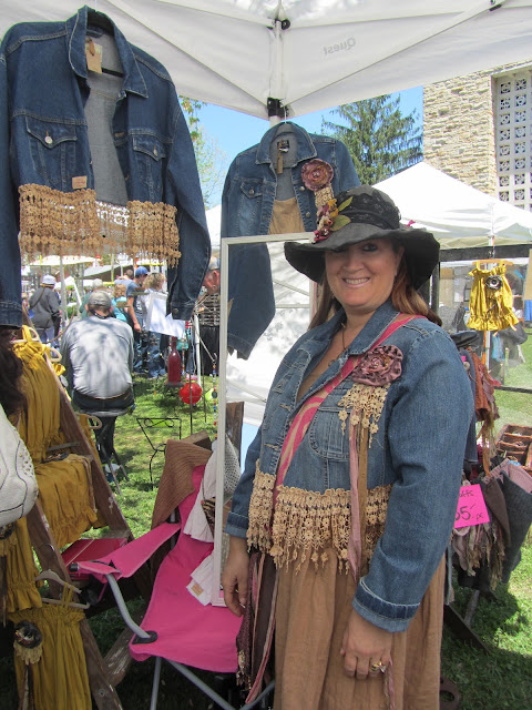 Cat posing in front of her booth wearing a gorgeous jean jacket