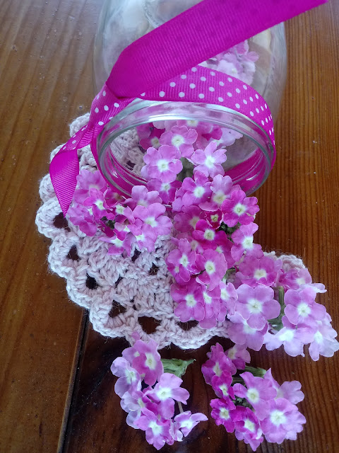 Composición floral con bote de cristal y flor de la verbena rosa