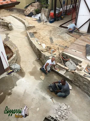 Bizzarri, da Bizzarri Pedras, trabalhando, fazendo a construção da escada de pedra com pedra Carranca sendo tipo cacão nas pisadas da escada e nos espelhos da escada a chapa de pedra moledo no mesmo estilo do muro de pedra.