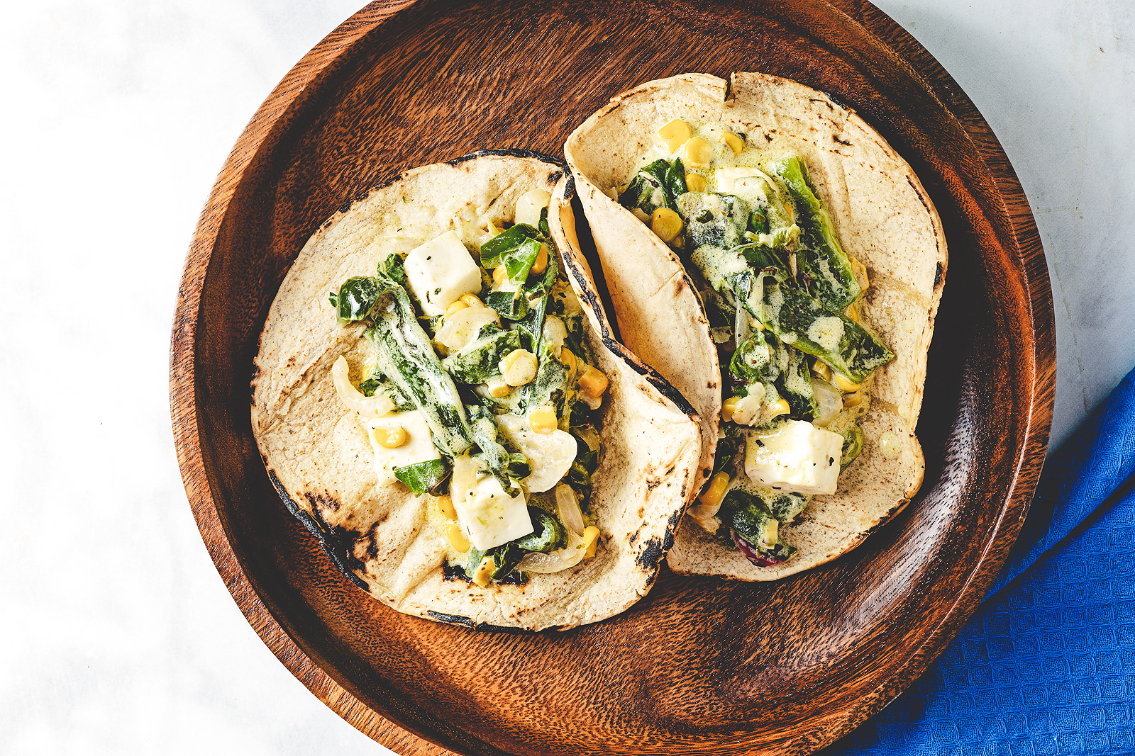 Tacos filled with roasted poblano, corn and chard in cream sauce.