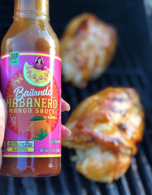 Habanero mango sauce next to chicken on grill