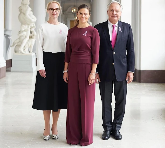 Crown Princess Victoria wore wine-red Kamille trousers and Kiana blouse from Andiata. Cancer Foundation's Secretary General Ulrika Arehed Kagstrom
