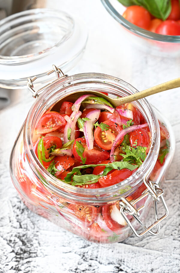 top view of a glass jar showing  preserved cherry tomatoes